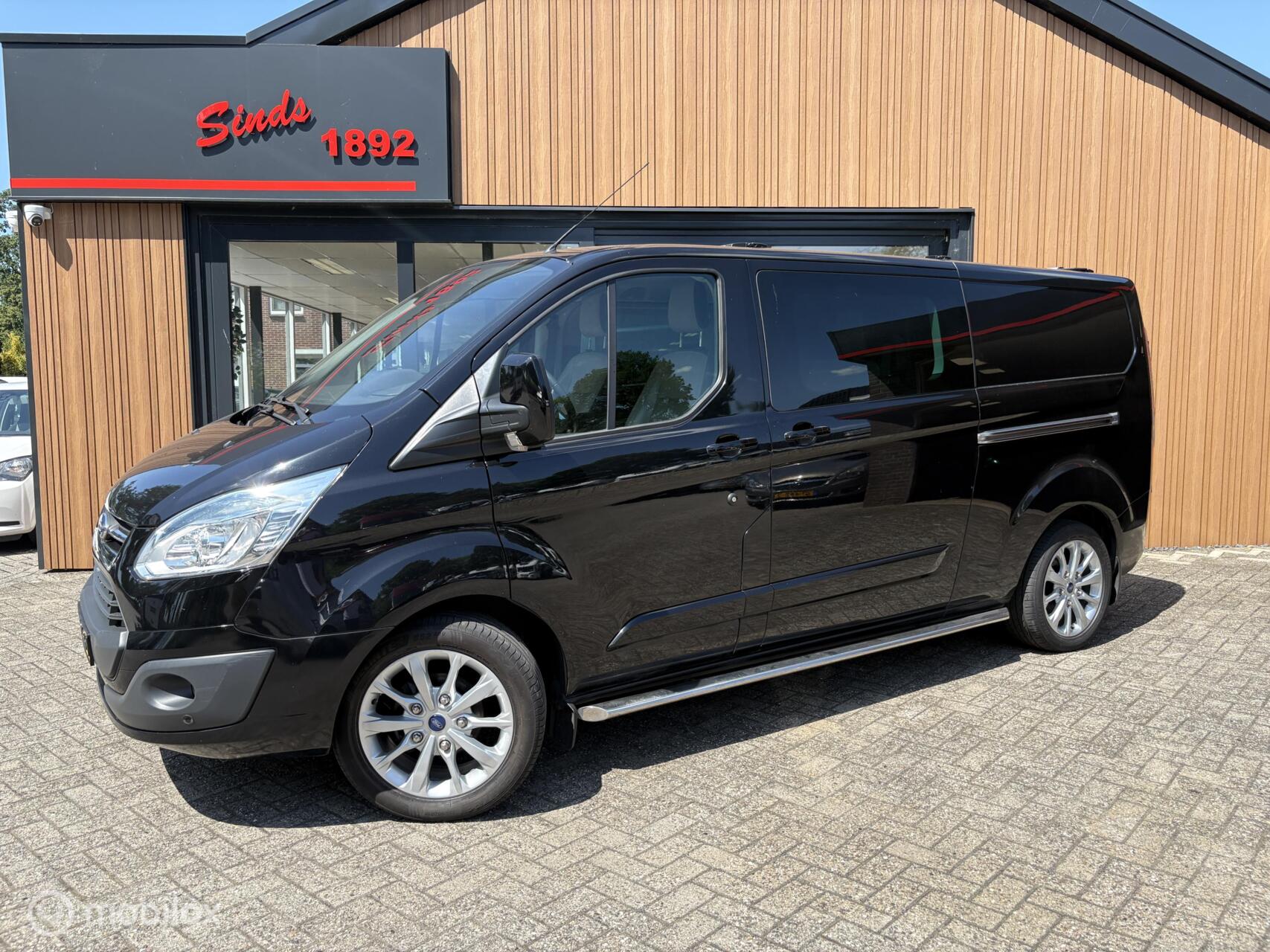 Ford Transit Custom 330 2.2 TDCI 125 Pk L2H1 | Limited Dubbele schuifdeur | Leder | Trekhaak | Stoelverwarming | Navi | Camera |18 Inch | PDC | TOPSTAAT 2016 - voorkant