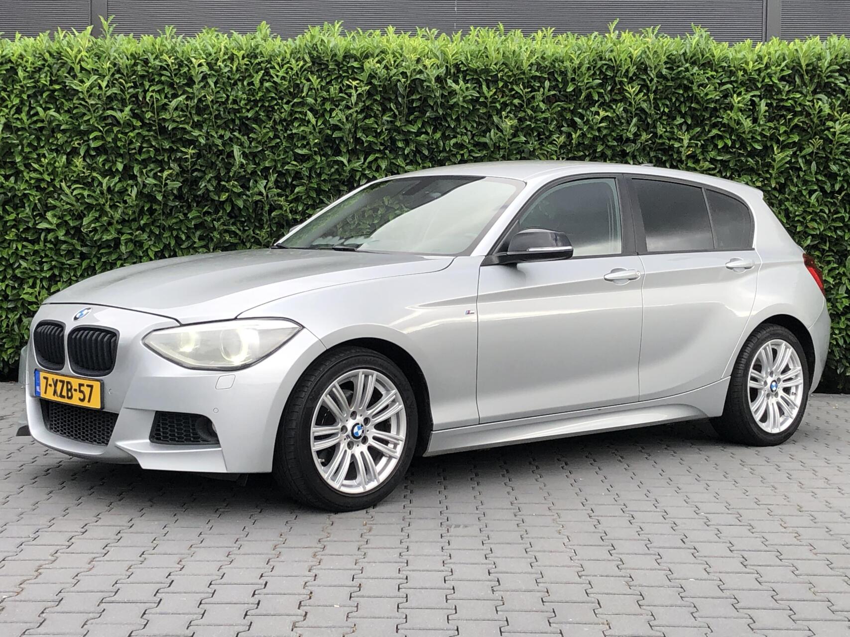 BMW 1er Reihe 118i Business+ NIEUW MODEL,  M PAKKET, NAVI, CRUISE, PDC V+A, LM VELGEN 17", XENON, STOELVERWARMING 2012 - voorkant