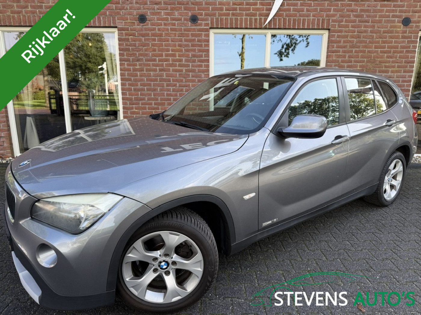 BMW X1 sDrive 18i sDrive 18i 150pk Aut. | Youngtimer Navi Clima Cruise 17" LMV Trekhaak Metallic | Voorschoten 2011 - voorkant